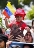 大統領選挙が行われたベネズエラの首都カラカス（Caracas）でベネズエラ国旗を掲げるウゴ・チャベス（Hugo Chavez）大統領の支持者ら（2012年10月7日撮影）。(c)AFP/Luis Acosta
