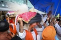 インドの首都にあるデリー国際空港で、アフガニスタンから退避してきたシーク教徒が持ち帰った同教の聖典「グル・グラント・サーヒブ」を運ぶ男性（2021年8月24日撮影）。(c)Money SHARMA / AFP
