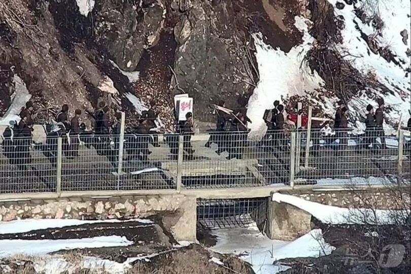 西部前線の監視哨所（GP）付近で作業道具と「封鎖」と書かれた看板を持って移動する北朝鮮軍兵士＝韓国合同参謀本部提供(c)news1