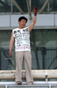 中国・北京（Beijing）の鉄道駅で15日、同国・黒竜江（Heilongjiang）省の役人の不正を訴えるTシャツを着た男が橋に上り、自ら手を切りつけた後で、飛び降りて抗議の意思を示すと訴えた。写真は、血まみれの手を掲げる男（2009年6月15日撮影）。(c)AFP