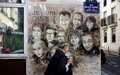 C215として知られるクリスチャン・ゲミ氏の描いた、シャルリー・エブド襲撃事件で殺害されたメンバーの壁画前を通る人（2020年8月31日撮影、資料写真）。(c)THOMAS COEX / AFP