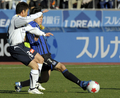 サッカー第88回天皇杯（%%The 88th Emperor&apos;s Cup%%）決勝、ガンバ大阪（%%Gamba Osaka%%）対柏レイソル（%%Kashiwa Reysol%%）。試合は延長後半11分に途中出場の播戸竜二（%%Ryuji Bando%%）が決勝点を挙げたガンバ大阪が1-0で競り勝ち優勝した。この結果、2008年にAFCチャンピオンズリーグ（%%AFC Champions League 2008%%）を制したガンバ大阪は、09年の同大会への出場権を獲得した。写真は柏レイソルの古賀正紘（%%Masahiro Koga%%）をかわしてパスを出すガンバ大阪の遠藤保仁（%%Yasuhito Endo%%、右）。（2009年1月1日撮影）(c)AFP/TOSHIFUMI KITAMURA