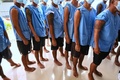 タイのチョンブリ中央刑務所で新型コロナウイルスのワクチン接種を受けるため並ぶ受刑者ら（2021年6月25日撮影）。(c)Lillian SUWANRUMPHA / AFP