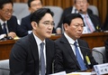 韓国・朴槿恵（パク・クネ）大統領の親友による国政介入疑惑に絡み、国会の聴聞会に呼ばれて証言するサムスン電子副会長の李在鎔（イ・ジェヨン）氏と、それを聞くロッテグループ会長の辛東彬（シン・ドンビン、重光昭夫）氏（2016年12月6日撮影）。(c)AFP/JUNG YEON-JE