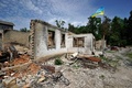 ウクライナ・キエフ州の破壊された民家にはためく国旗（2022年6月2日撮影）。(c)SERGEI CHUZAVKOV / AFP