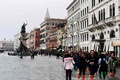イタリア北部ベネチアで高潮警報が出る中、冠水した広場の近くを歩く人々（2018年10月29日撮影）。(c)Miguel MEDINA / AFP