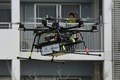 千葉市で宅配サービスの実証実験を行うドローン（2016年4月11日撮影）。(c)AFP/TORU YAMANAKA