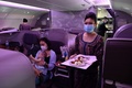シンガポールのシンガポール（チャンギ）国際空港に駐機された、シンガポール航空の旅客機内に期間限定で開かれたレストランで、笑顔を振りまく客室乗務員（2020年10月24日撮影）。(c)ROSLAN RAHMAN / AFP