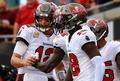 21NFL第7週、タンパベイ・バッカニアーズ対シカゴ・ベアーズ。タッチダウンが決まり喜ぶタンパベイ・バッカニアーズのトム・ブレイディ（左、2021年10月24日撮影）。(c)Mike Ehrmann/Getty Images/AFP