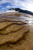 米イエローストーン国立公園（Yellowstone National Park）内のミッドウエーガイザーベイスン（Midway Geyser Basin）で、温泉グランド・プリズマティック・スプリング（Grand Prismatic Spring）から流れ出し階段状に沈着した鉱物。

1872年に米国初の国立公園として設立されたイエローストーンには、1万を超える間欠泉や泥間欠泉、蒸気孔、温泉がある。ワイオミング（Wyoming）、モンタナ（Montana）、アイダホ（Idaho）の3州にまたがり、公園名はイエローストーン川（Yellowstone River）にちなんでいる（2012年10月8日撮影）。(c)AFP/Karen BLEIER