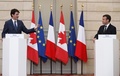 仏パリのエリゼ宮（大統領府）で共同記者会見に臨むエマニュエル・マクロン仏大統領（右）とカナダのジャスティン・トルドー首相（2018年4月16日撮影）。(c)AFP PHOTO / POOL
