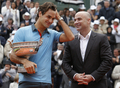 全仏オープンテニス2009（%%French Open 2009%%）男子シングルス決勝。大会第2シードのロジャー・フェデラー（%%Roger Federer%%、スイス）は、大会第23シードのロビン・ソデルリング（%%Robin Soderling%%、スウェーデン）と対戦。フェデラーは6-1、7-6、6-4で全仏初優勝を果たし、ピート・サンプラス（%%Pete Sampras%%、米国）氏の持つグランドスラム最多優勝記録（14勝）に並ぶと同時に、史上6人目の生涯グランドスラム（4大大会全制覇）を達成した。写真は表彰式に臨む元テニス選手のアンドレ・アガシ（%%Andre Agassi%%）氏とロジャー・フェデラー（左）。（2009年6月7日撮影）(c)AFP/PATRICK KOVARIK