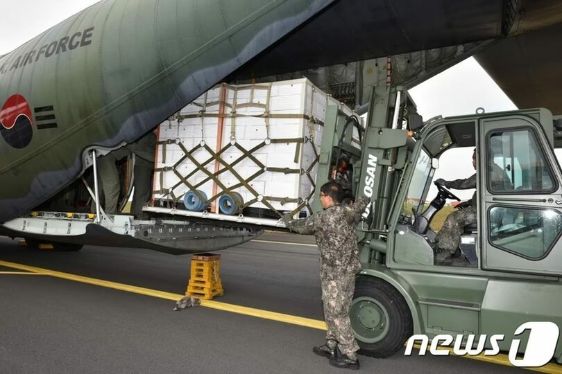 済州空港で、北朝鮮へ送る済州産ミカンを空軍C-130輸送機に積み込む兵士ら(c)news1