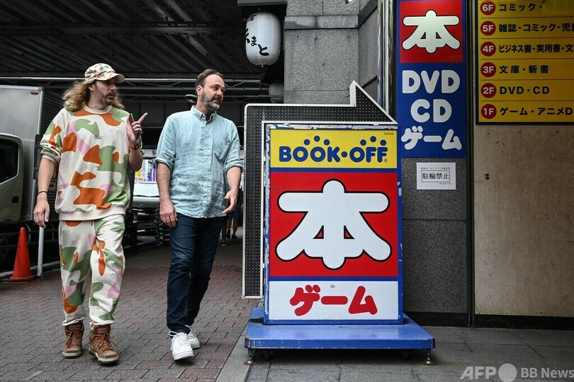 東京・秋葉原で、中古ゲームショップ巡りをするリュドビク・シャルルさん（右）とブノア・テブニさん（2023年10月10日撮影）。(c)Richard A. Brooks / AFP