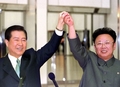 北朝鮮・平壌（Pyongyang）で韓国の金大中（キム・デジュン、Kim Dae-Jung）大統領（当時、左）と南北首脳会談を行い、南北共同宣言に署名する前に同大統領とつないだ手を掲げる北朝鮮の金正日（キム・ジョンイル、Kim Jong-Il）総書記（2000年6月14日撮影）。(c)AFP