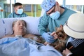 スペイン・バルセロナで、飼い犬の「ルナ」をなでるマルタ・パスクアルさん。新型コロナウイルス感染症（COVID-19）にかかったパスクアルさんが、新鮮な空気を吸えるようにと、病院スタッフが外に連れ出した（2021年3月4日撮影）。(c) LLUIS GENE / AFP