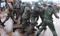 ギニアの首都コナクリ（Conakry）で行われた軍事政権に対する抗議集会の会場となったスタジアム前で、参加者を拘束する警官（2009年9月28日撮影）。(c)AFP/SEYLLOU