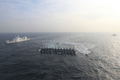韓国沖の黄海（Yellow Sea）で21日、違法操業中に韓国海洋警察庁による取り締まりを受けた中国漁船12隻が、船体を互いにロープで縛ってひとかたまりの大船団を作り上げ、逃走を図った。黄海の韓国の排他的経済水域（EEZ）では中国漁船による密漁が常態化しており、海洋警察庁によると過去1年に332隻を拿捕したという（2010年12月21日撮影）。(c)AFP/PARK YOUNG-CHUL