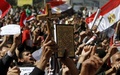 エジプトの首都カイロ（Cairo)市内タハリール広場（Tahrir Square）で開かれた宗教対立への抗議集会で、キリスト教の十字架とイスラム教の聖典コーラン（Koran）を掲げる参加者（2011年3月11日、資料写真）。(c)AFP/MAHMUD HAMS