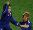 2010年サッカーW杯南アフリカ大会（%%2010 World Cup%%）1次リーグE組、デンマーク対日本。日本は3-1で勝利し、勝ち点6（2勝1敗）の同組2位で決勝トーナメントに進んだ。日本の決勝トーナメント進出は、自国開催以外のW杯では初めて。写真は前半30分にチームの2点目を決め、本田圭佑（%%Keisuke Honda%%、右）から祝福される日本の遠藤保仁（%%Yasuhito Endo%%）。（2010年6月24日撮影）(c)AFP/PEDRO UGARTE