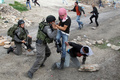 パレスチナ自治区ヨルダン川西岸（West Bank）で、イスラエルによるパレスチナ人の土地の収用に対する抗議行動後の衝突で、パレスチナ人の少年を拘束しようとするイスラエル軍兵士（2013年3月1日撮影）。(c)AFP/JAAFAR ASHTIYEH