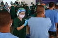 タイのチョンブリ中央刑務所で新型コロナウイルスのワクチン接種を受ける受刑者ら（2021年6月25日撮影）。(c)Lillian SUWANRUMPHA / AFP