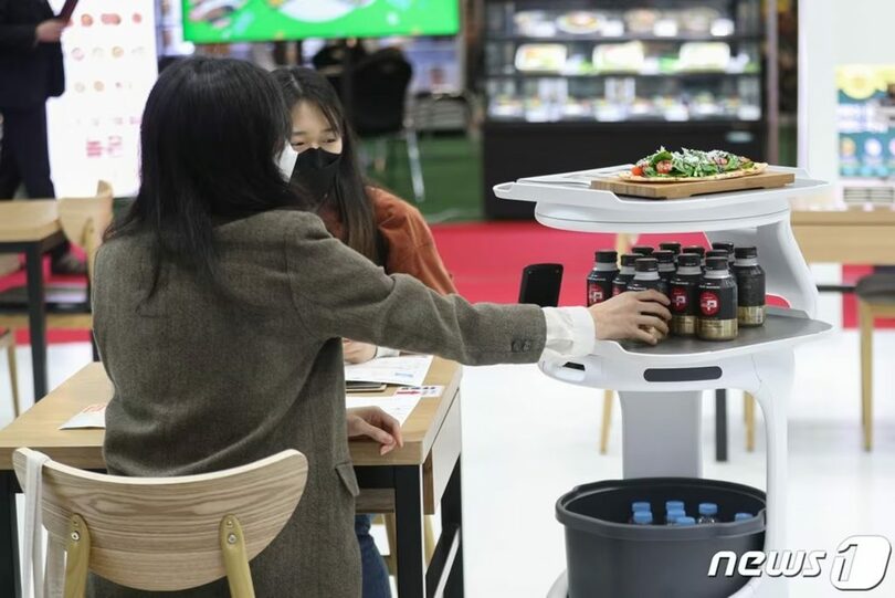 ソウル・江南区のCOEXで開かれた「2022 第52回 IFSフランチャイズソウル上半期」展示会で配膳ロボットを体験する来場者(c)news1