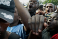 ハイチの首都ポルトープランス（Port-au-Prince）で、崩壊した大統領官邸前で、フェンスの内側に姿を現したルネ・プレバル（Rene Preval）ハイチ大統領に向かって叫ぶ市民（2010年1月30日撮影）。(c)AFP/JEAN-PHILIPPE KSIAZEK