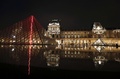 パリ（Paris）のルーブル（Louvre）美術館にあるガラスのピラミッドに設置された、赤いネオンライトを使ったクロード・レベック（Claude Leveque）氏による作品（2014年4月2日撮影）。(c)AFP/FRANCOIS GUILLOT