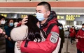 中国北東部・遼寧省瀋陽の空港で、武漢に向かうに当たって家族や友人に見送られる医療従事者ら（2020年2月2日撮影）。(c)STR / AFP