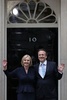 英ロンドンの首相官邸前で写真撮影に応じるリズ・トラス新首相と夫のヒュー・オレアリー氏（2022年9月6日撮影）。(c)ADRIAN DENNIS / AFP
