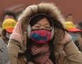深刻な大気汚染と砂嵐に見舞われた中国・北京（Beijing）で、マスクで自衛した女性（2013年2月28日撮影）。(c)AFP/Mark RALSTON