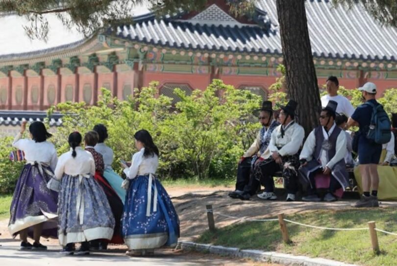 2025年5月18日、ソウルの景福宮で日差しを避けて休んでいる観光客(c)NEWSIS