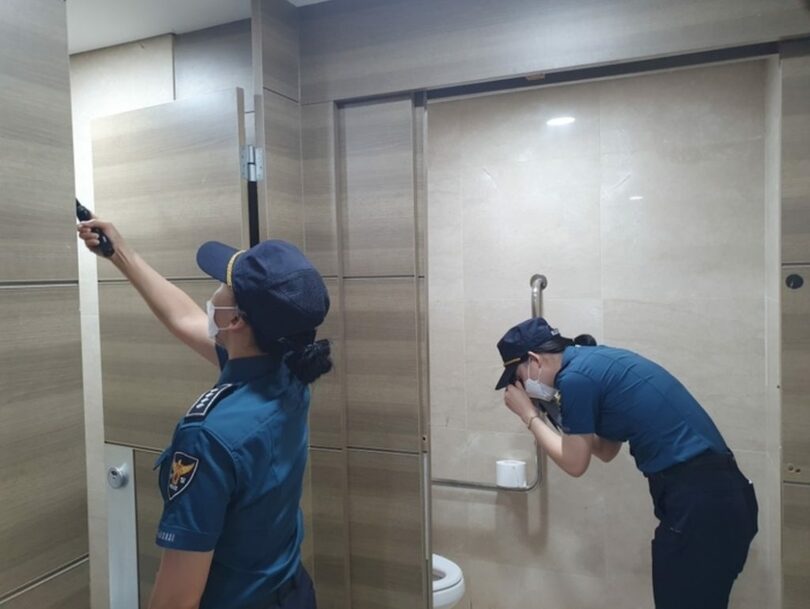 公衆トイレの盗撮カメラの有無を点検する警察官(c)NEWSIS