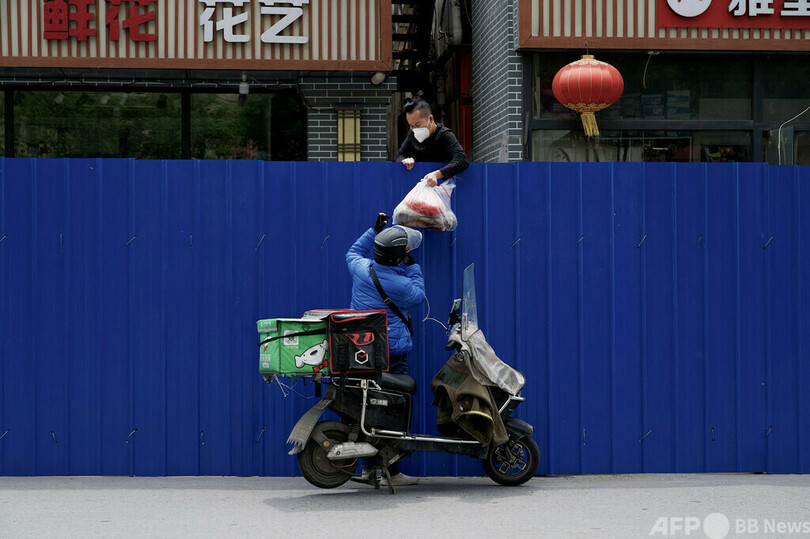 【今日の1枚】フェンス越しの食品リレー、封鎖下の北京