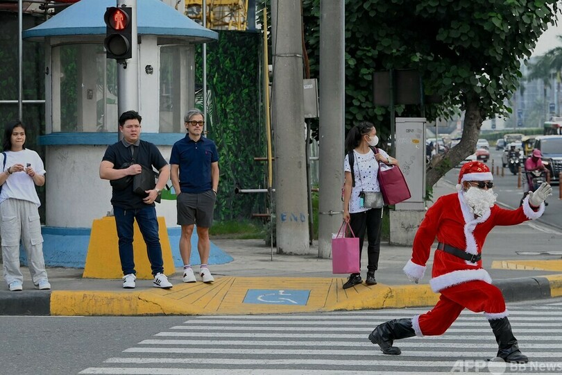 人々を幸せに、自分は健康に 踊るサンタが交通整理 マニラ