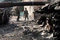 グルジア・南オセチア（South Ossetia）自治州のツヒンバリ（Tskhinvali）で、戦闘で破壊されたグルジア軍戦車を調査する自治州兵士（2008年8月11日撮影）。(c)AFP/ANDREI SMIRNOV