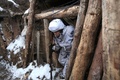 ウクライナ東部ドネツク州ベルヒノトレーツケ村付近の親ロシア分離独立派との前線で、塹壕から出るウクライナの兵士（2022年2月1日撮影）。(c)Anatolii STEPANOV / AFP