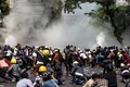 ミャンマー・マンダレーで行われた軍事クーデターに抗議するデモで、警察による催涙ガスの使用を受けて身構える参加者ら（2021年3月3日撮影）。(c)STR / AFP