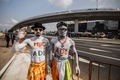 コートジボワール・アビジャン郊外に建設された、日本が資金協力した高架橋を背に撮影に応じる男性2人（2019年12月16日撮影）。(c)SIA KAMBOU / AFP