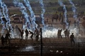 パレスチナ自治区ガザ地区のイスラエルとの境界付近で、催涙ガスから逃げるパレスチナ人（2018年6月8日撮影）。(c)AFP PHOTO / JACK GUEZ