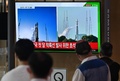 韓国初の月探査機を載せた宇宙開発企業スペースXの「ファルコン9」ロケットの打ち上げを報じるニュースを見る人々。ソウルの鉄道駅にて（2022年8月5日撮影）。(c) Jung Yeon-je / AFP