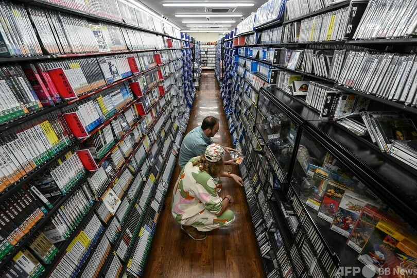 東京・秋葉原で、中古ゲームショップで希少なゲームを探すリュドビク・シャルルさん（奥）とブノア・テブニさん（2023年10月10日撮影）。(c)Richard A. Brooks / AFP