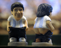 　スペイン・カタルーニャ（Catalonia）地方で、今年もクリスマス恒例の排便人形「カガネル（Caganer、「排便」の意）がお目見えした。カタルーニャでは、クリスマスシーズンになると有名人が排泄する姿を模した陶器の人形を自宅内に隠し、招待客に探させるのが恒例行事となっている。18世紀から続く風習で、カガネルは翌年の豊穣（ほうじょう）、希望、繁栄の象徴とされている。

　写真は、バルセロナ（Barcelona）のクリスマス市に登場したサッカー・アルゼンチン代表のディエゴ・マラドーナ（Diego Maradona）監督のカガネル（2009年12月21日撮影）。(c)AFP/LLUIS GENE
