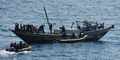 アフリカ・ソマリア沖のアデン湾（Gulf of Aden）で、海賊船に乗り込み掃討作戦を行うインド海軍と、手を上げて降参する海賊（2008年12月13日撮影）。(c)AFP/INDIAN NAVY