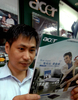 2007年8月28日、台湾の首都台北（Taipei）のパソコンショップでエイサー（Acer）のパンフレットを読む男性。(c)AFP/Sam YEH