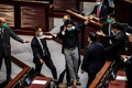 香港立法会（議会）で、中国国歌への侮辱行為に罰則を科す国歌条例案の審議中に、警備担当者らともみ合いになる民主派議員ら（2020年6月4日撮影）。(c)ISAAC LAWRENCE / AFP