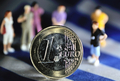 ギリシャ国旗の上に置かれた1ユーロ硬貨と、それを取り囲む人形（2012年8月24日撮影、資料写真）。(c)AFP/PHILIPPE HUGUEN