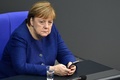 独ベルリンの連邦議会（下院）で携帯電話を手にするアンゲラ・メルケル首相（2020年12月8日撮影、資料写真）。(c)John MACDOUGALL / AFP