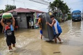 台風16号が通過した後のフィリピン・ブラカン州サンイルデフォンソで、自宅から荷物を持ち出す人（2022年9月26日撮影）。(c)TED ALJIBE / AFP